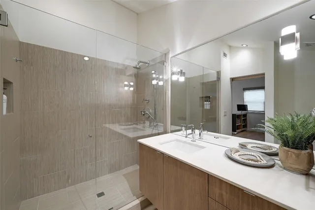 a bathroom with a sink a potted plant and a shower