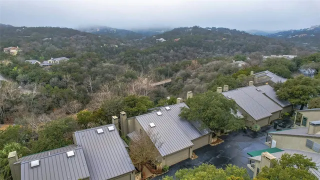 an aerial view of a house with a yard and mountain view in back