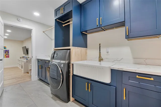 a large white kitchen with stainless steel appliances granite countertop a stove a sink dishwasher and white cabinets with wooden floor