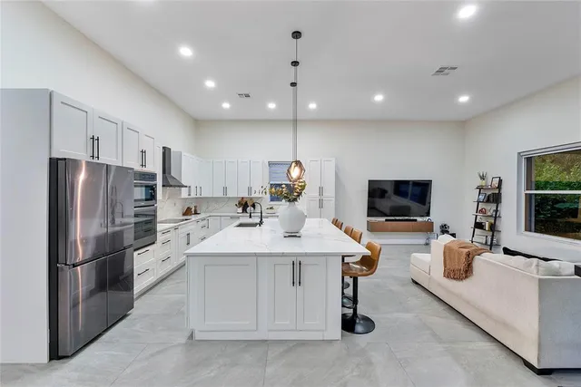 a kitchen with stainless steel appliances granite countertop a sink stove and refrigerator