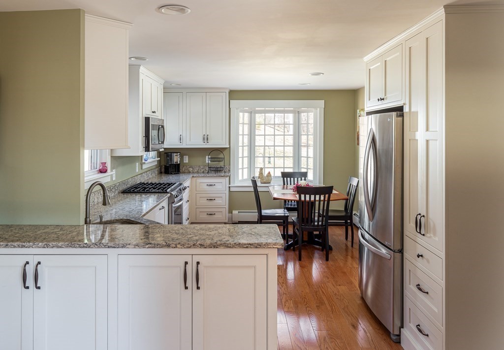 61 Ayer Road Harvard, MA 01451 - Photo 15 of 32 a kitchen with granite countertop a sink a stove a dining table and chairs