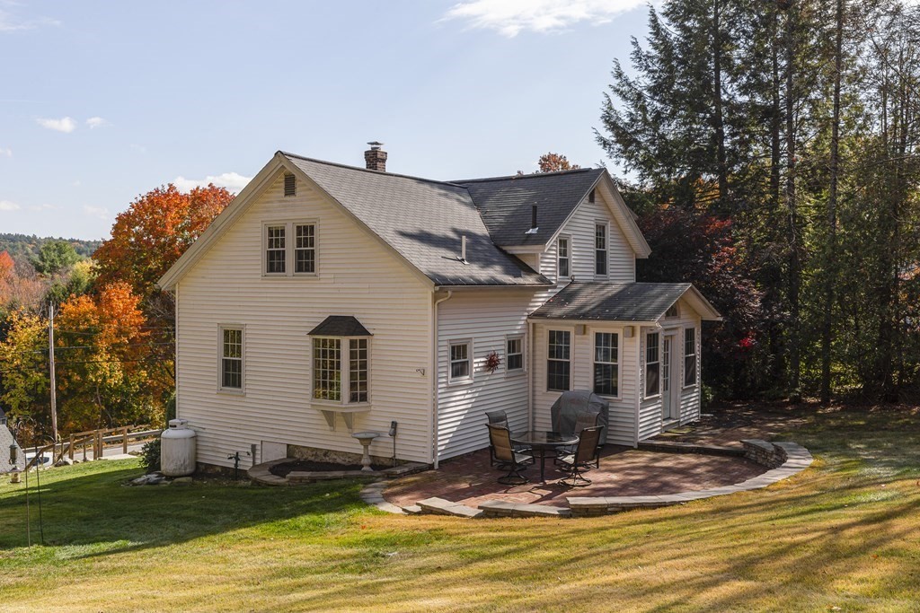61 Ayer Road Harvard, MA 01451 - Photo 6 of 32 a view of a white house with large windows and a small yard