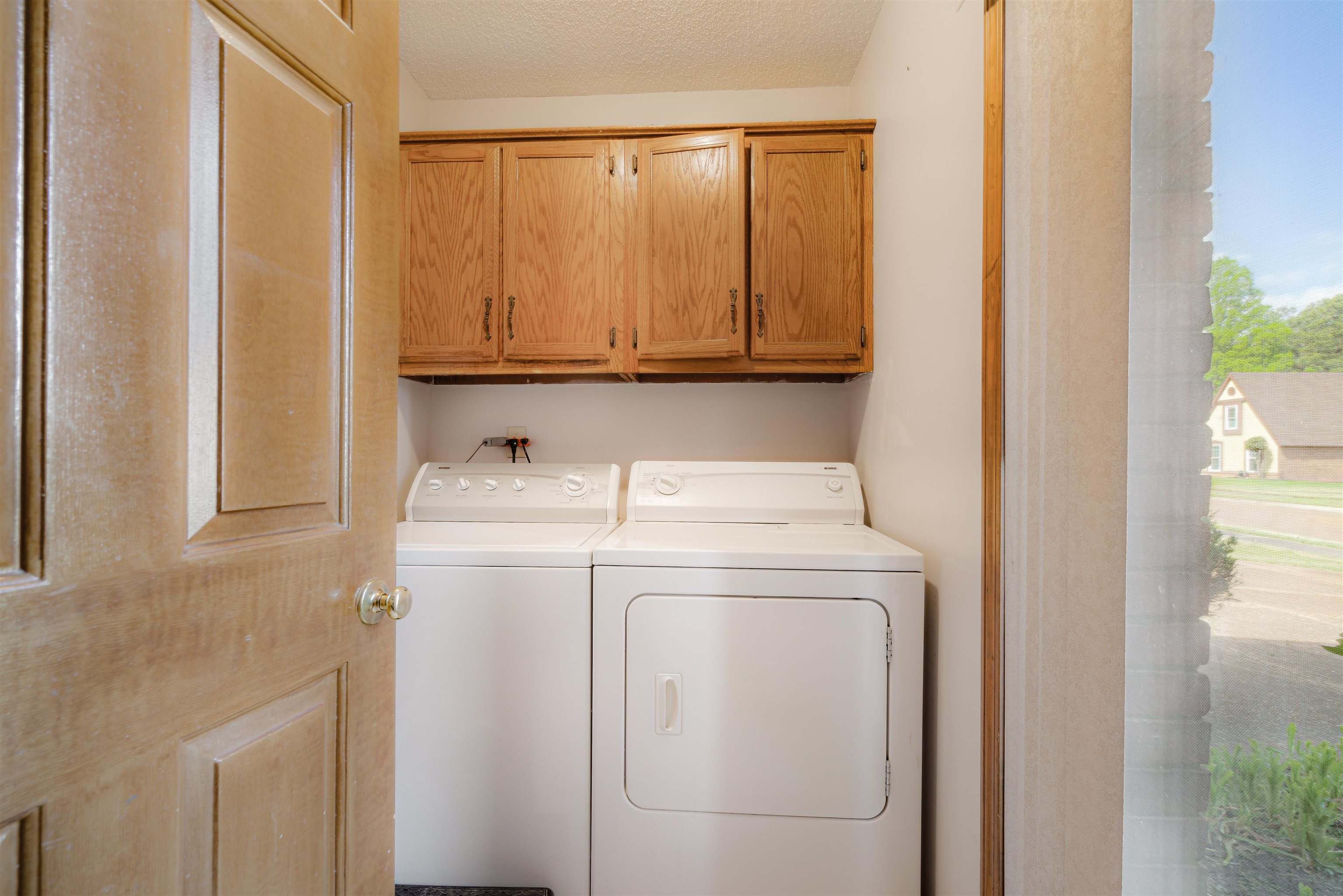 7063 Cutter Mill Road Memphis, TN 38141 - Photo 14 of 29 Clothes washing area featuring cabinet space, a textured ceiling!