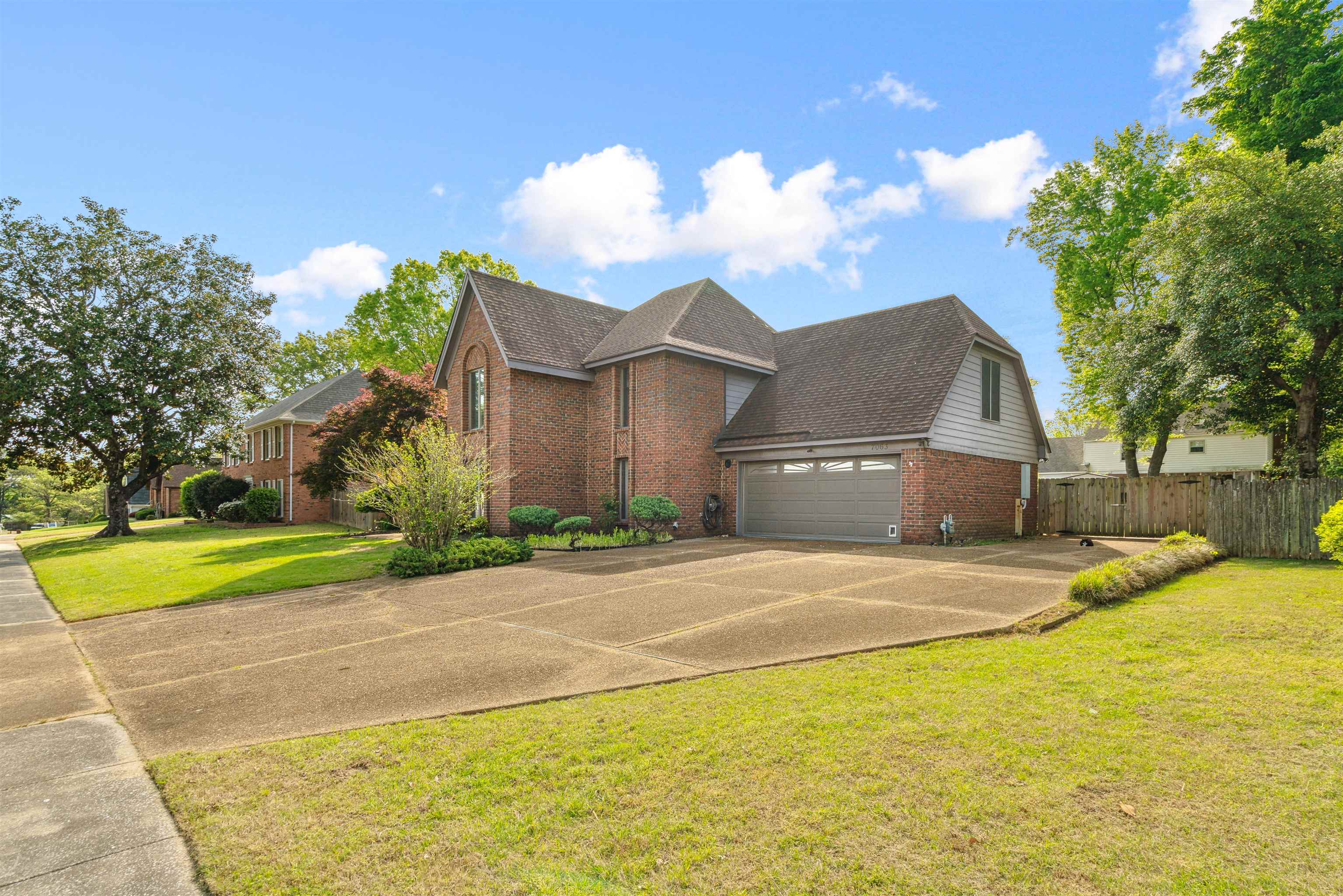 7063 Cutter Mill Road Memphis, TN 38141 - Photo 2 of 29 View of front of house featuring concrete driveway, fence, brick siding, an attached garage, and a front yard