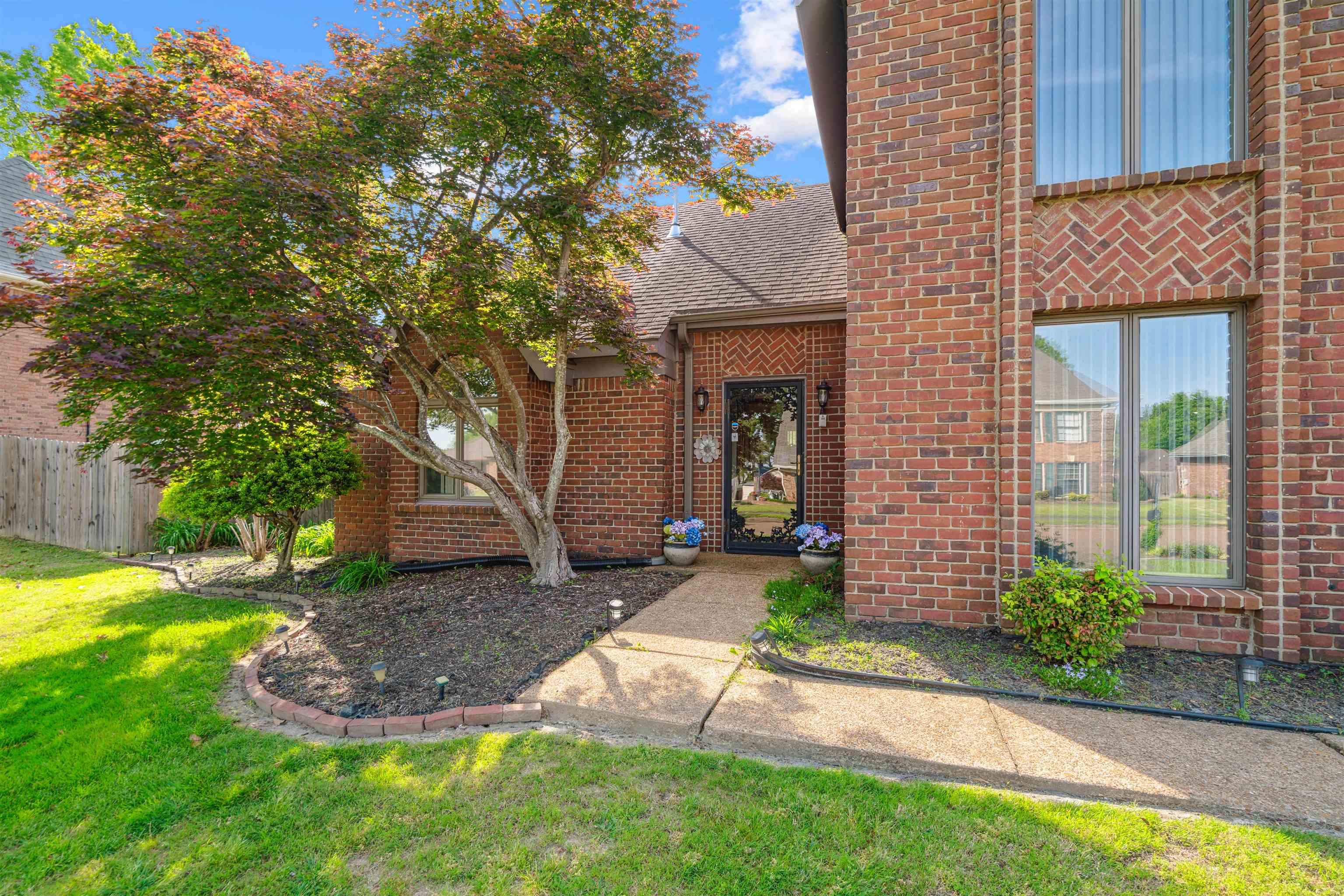 7063 Cutter Mill Road Memphis, TN 38141 - Photo 3 of 29 Property entrance featuring fence, a shingled roof, brick siding, and a yard