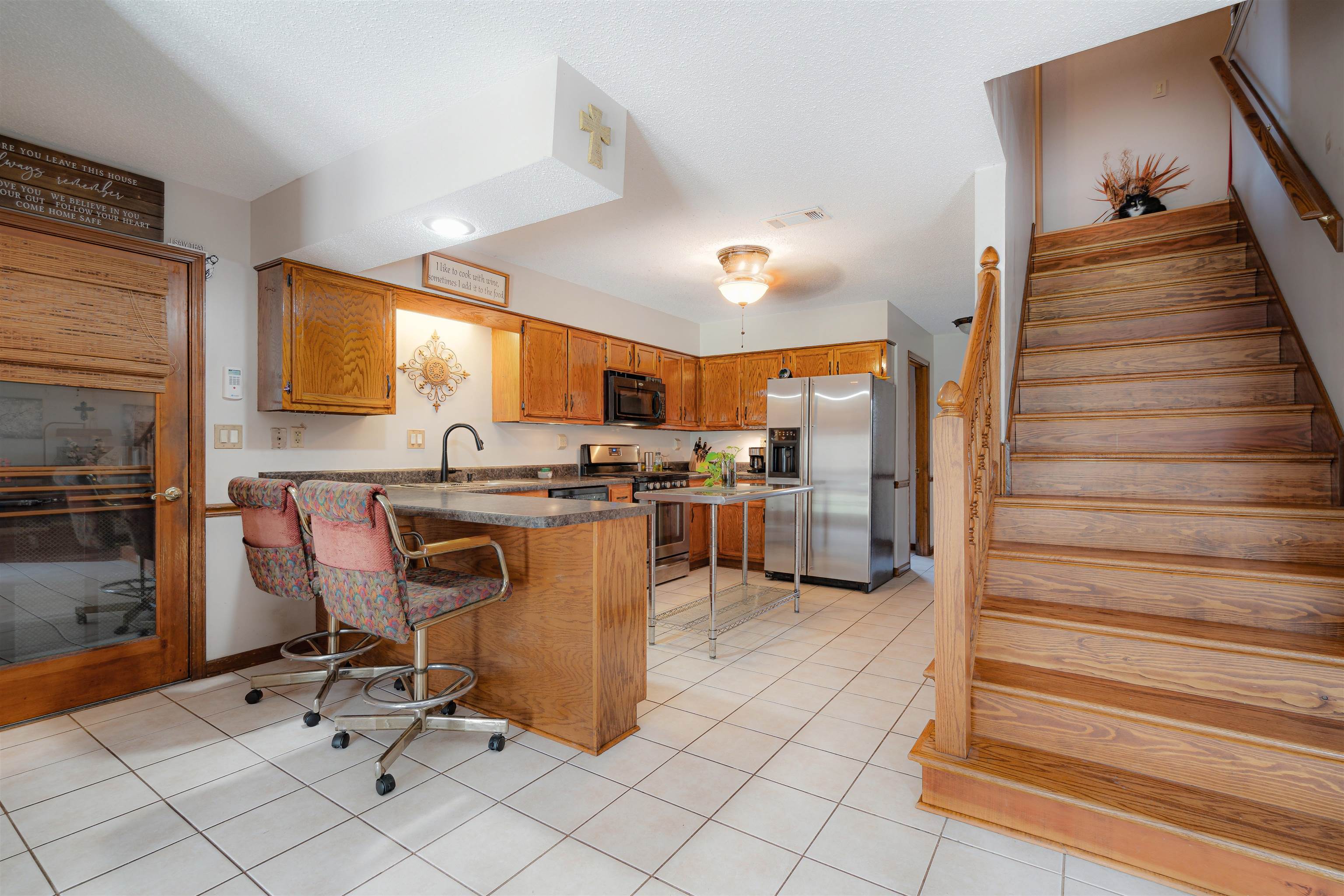 7063 Cutter Mill Road Memphis, TN 38141 - Photo 7 of 29 Kitchen featuring a kitchen breakfast bar, brown cabinetry, stainless steel appliances, a peninsula, and visible vents
