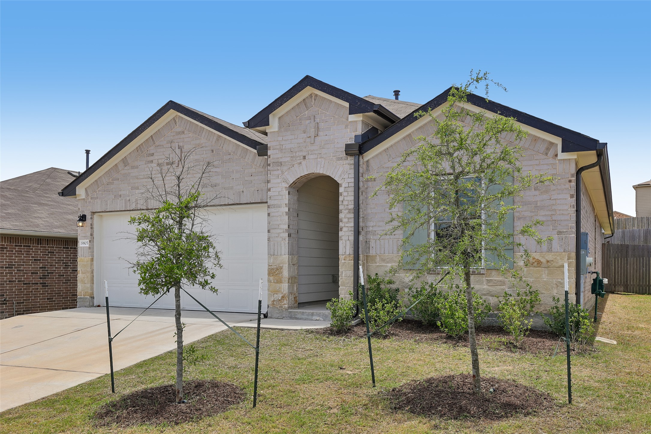 19805 Abigail Fillmore Road Manor, TX 78653 - Photo 2 of 40 A well-maintained facade showcasing brick and stone accents provides inviting curb appeal.