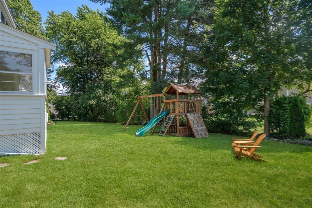 36 Autumn Circle Canton, MA 02021 - Photo 27 of 32 a view of a backyard with a slide trees and wooden fence