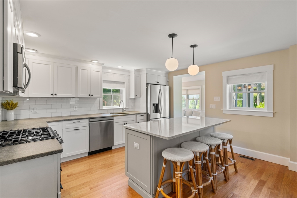 36 Autumn Circle Canton, MA 02021 - Photo 3 of 32 a large kitchen with granite countertop a stove a sink a dining table and chairs
