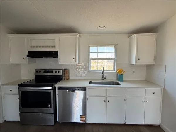 a kitchen with granite countertop a stove and a sink