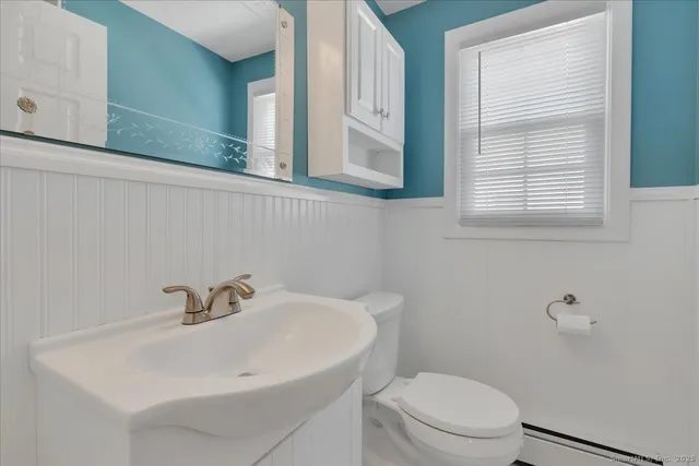 a bathroom with a sink a toilet and a mirror