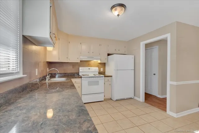 a kitchen with a refrigerator sink and cabinets
