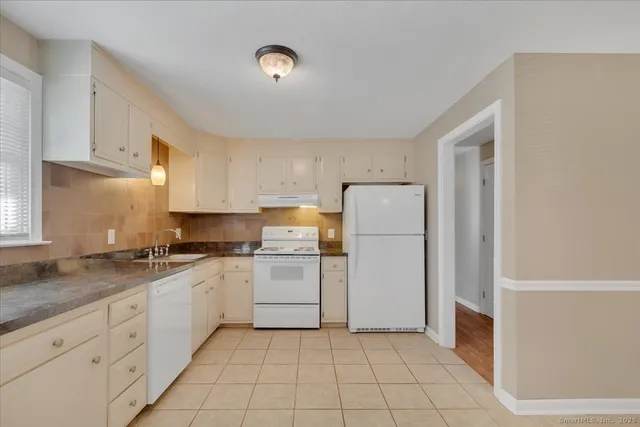 a kitchen with a sink a refrigerator and cabinets