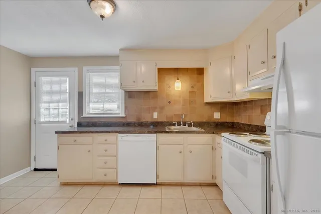 a kitchen with granite countertop white cabinets and white appliances