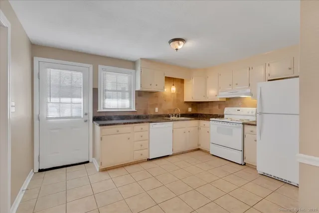 a kitchen with a refrigerator and white cabinets