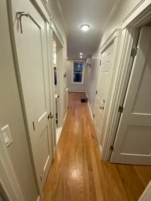 a view of a hallway with wooden floor and staircase