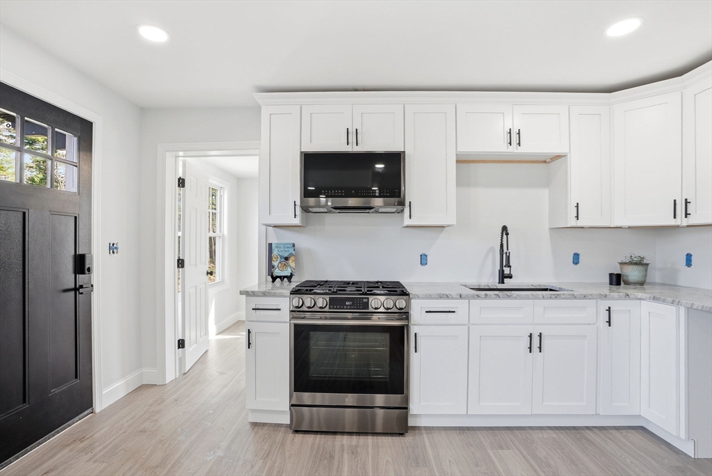 357 Wareham Street Middleboro, MA 02346 - Photo 3 of 42 a kitchen with white cabinets and stainless steel appliances