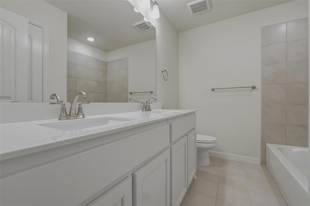1113 Trinity Drive Springtown, TX 76082 - Photo 31 of 40 Spa-inspired primary bathroom featuring a dual-sink vanity with white cabinetry, quartz countertop, and brushed nickel faucets