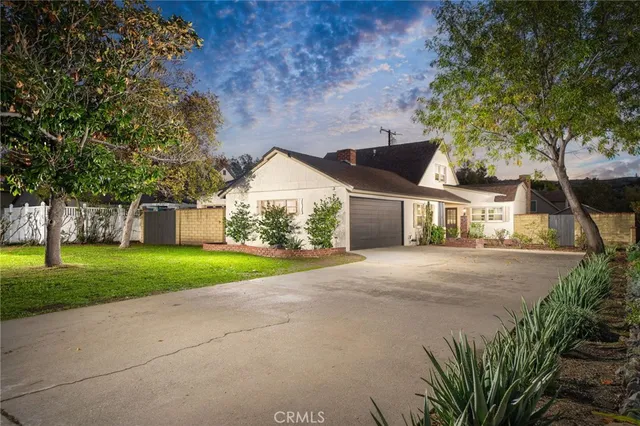 a view of a house next to a yard with big trees