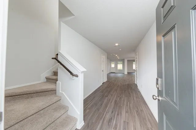 a view of a hallway with wooden floor and staircase