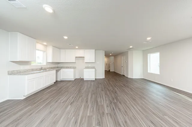 a large kitchen with wooden floors and white stainless steel appliances