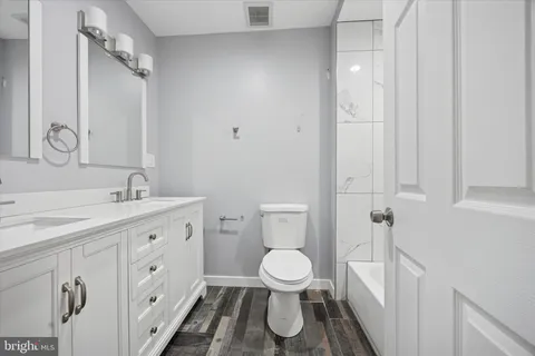 a bathroom with a toilet a sink and a large mirror