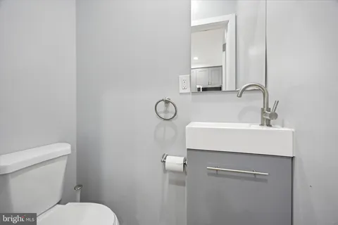 a bathroom with a toilet a sink and mirror