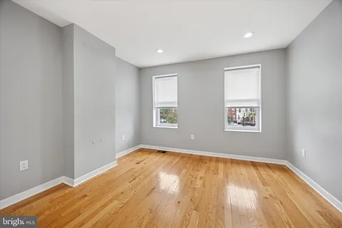 a view of empty room with wooden floor