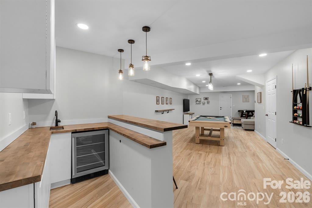 56 Great Horned Owl Road Candler, NC 28715 - Photo 22 of 32 a kitchen with stainless steel appliances granite countertop a sink dishwasher a stove and a refrigerator with wooden floor
