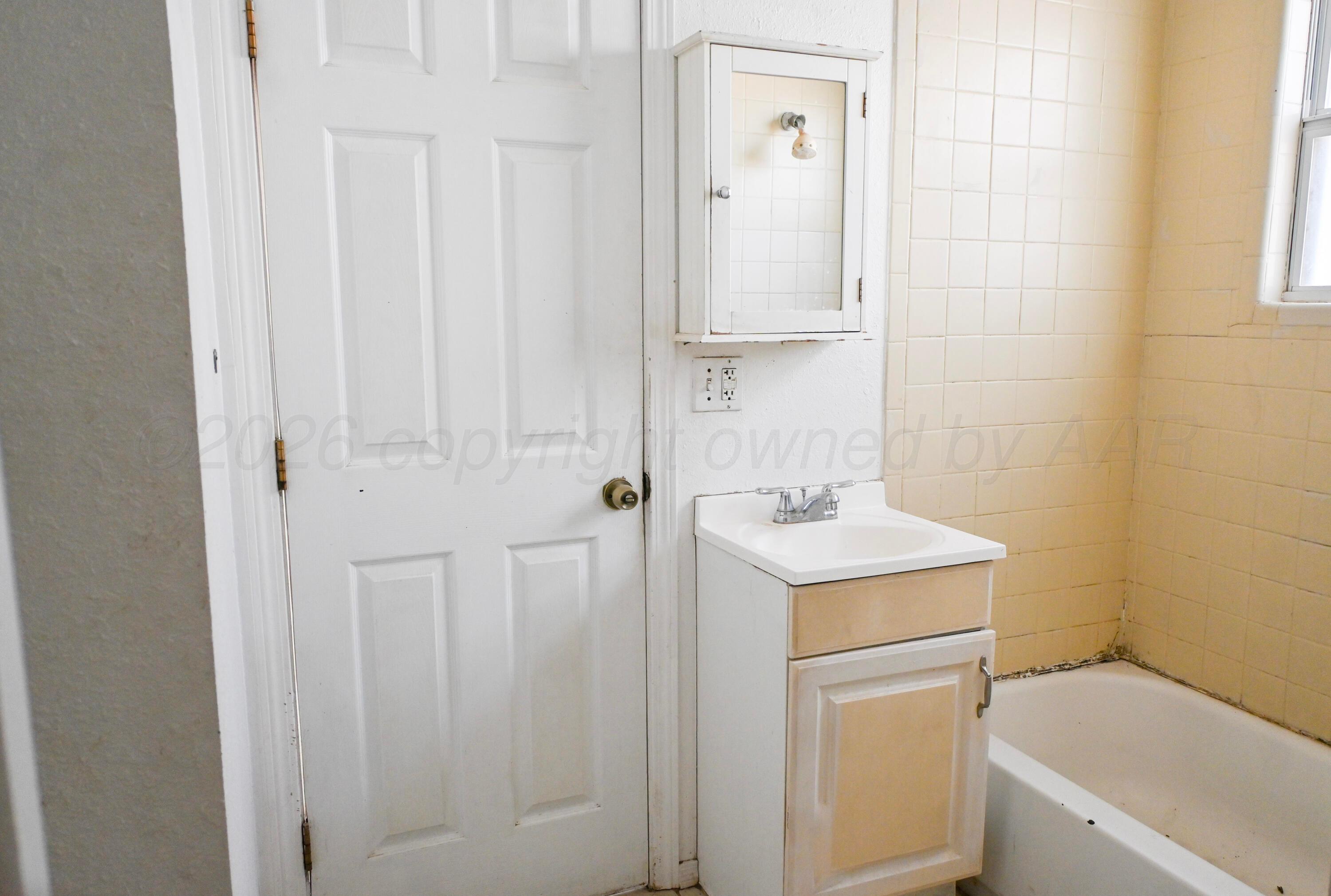 1210 Southwest 12th Avenue Amarillo, TX 79102 - Photo 7 of 12 a bathroom with a sink a toilet and a mirror