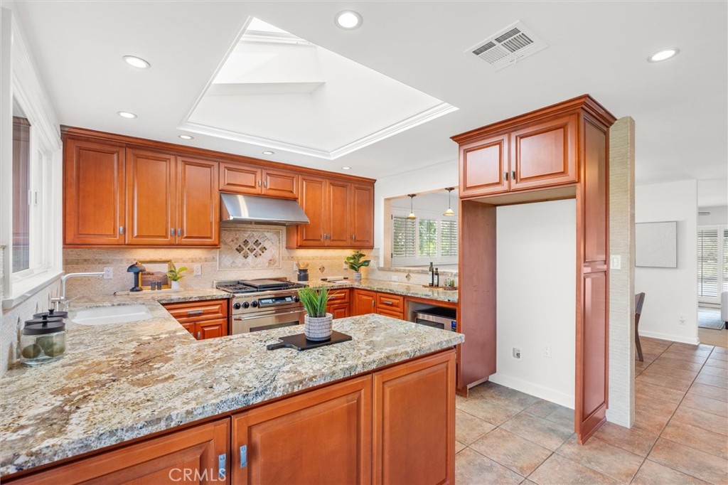 6301 East Bixby Hill Road Long Beach, CA 90815 - Photo 12 of 48 a kitchen with stainless steel appliances granite countertop a sink stove and refrigerator