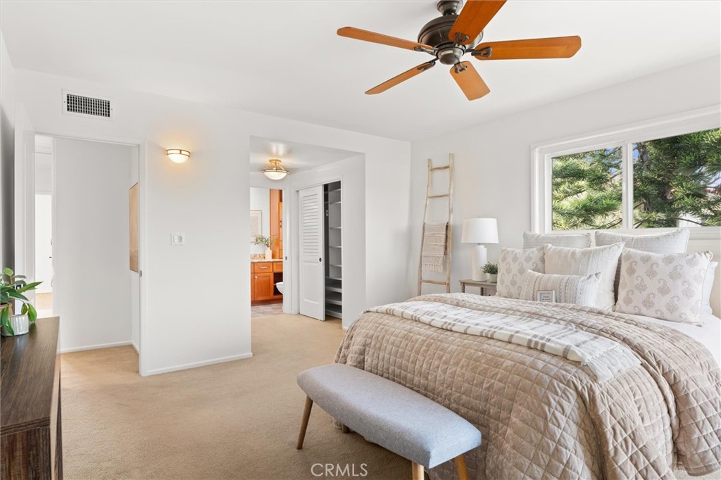 6301 East Bixby Hill Road Long Beach, CA 90815 - Photo 19 of 48 a spacious bedroom with a bed a ceiling fan and a rug