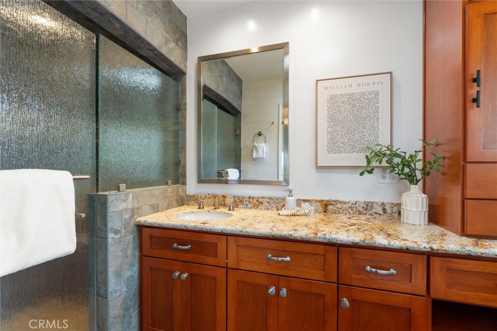 6301 East Bixby Hill Road Long Beach, CA 90815 - Photo 20 of 48 a bathroom with a granite countertop sink and a mirror