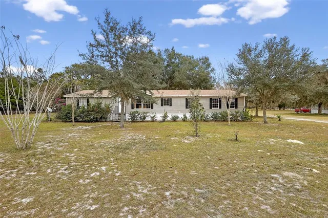 a house view with swimming pool and trees in the background