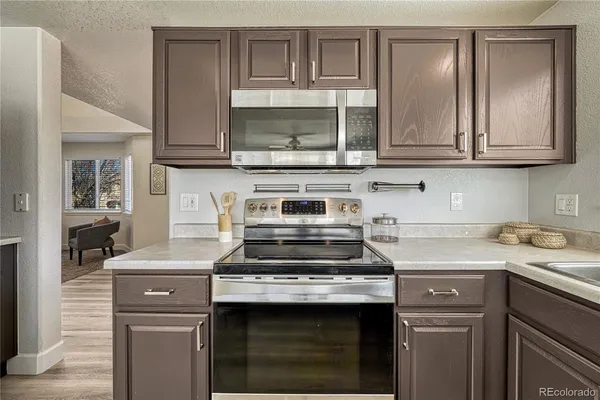 a kitchen with stainless steel appliances granite countertop a stove and a microwave