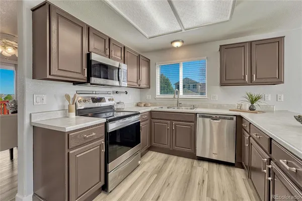 a kitchen with stainless steel appliances granite countertop a sink stove and microwave