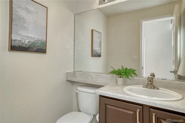 a bathroom with a granite countertop toilet sink and mirror