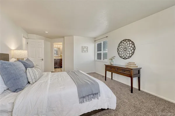 a bedroom with a bed a mirror and a table