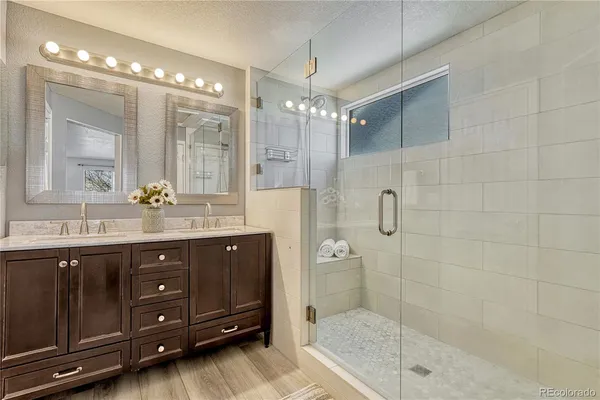 a bathroom with a sink shower and a mirror