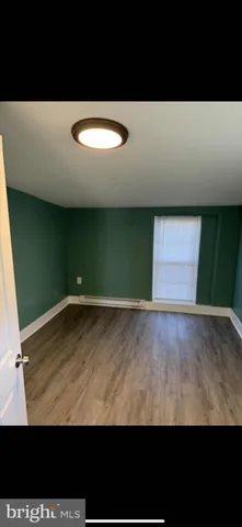 a view of an empty room with window and stairs