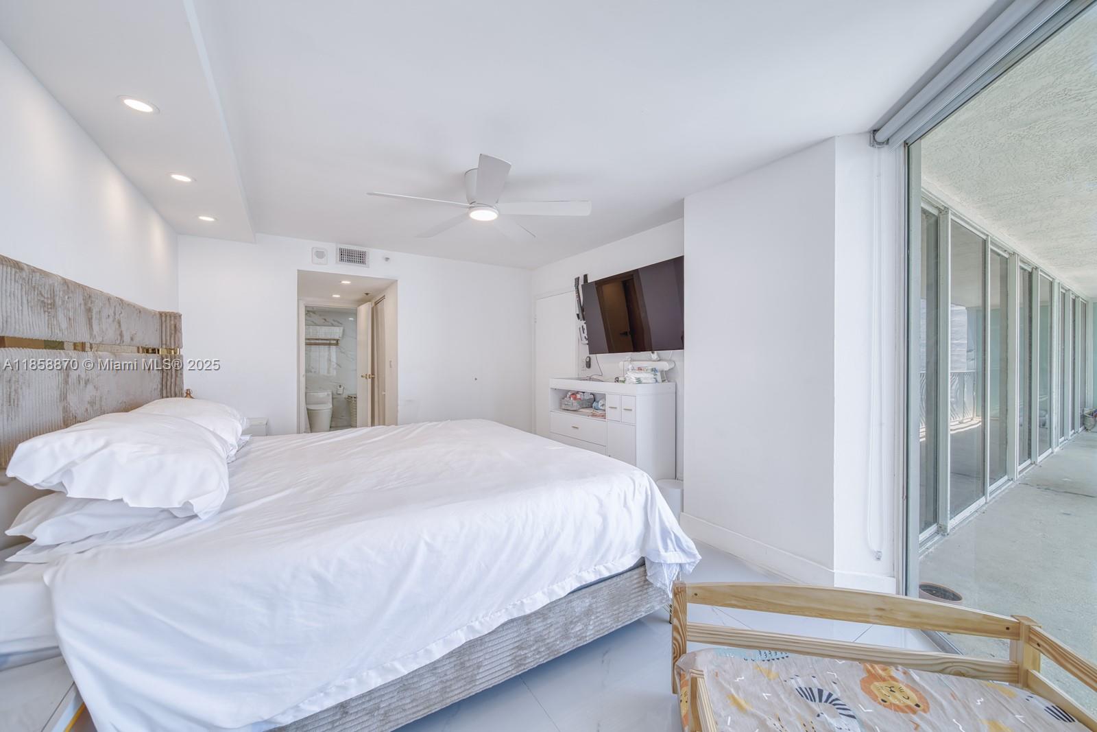 7601 East Treasure Drive, Unit 2424 North Bay Village, FL 33141 - Photo 12 of 25 a bedroom with a bed and a flat screen tv