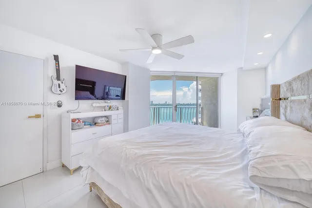 a bedroom with a bed and a large window