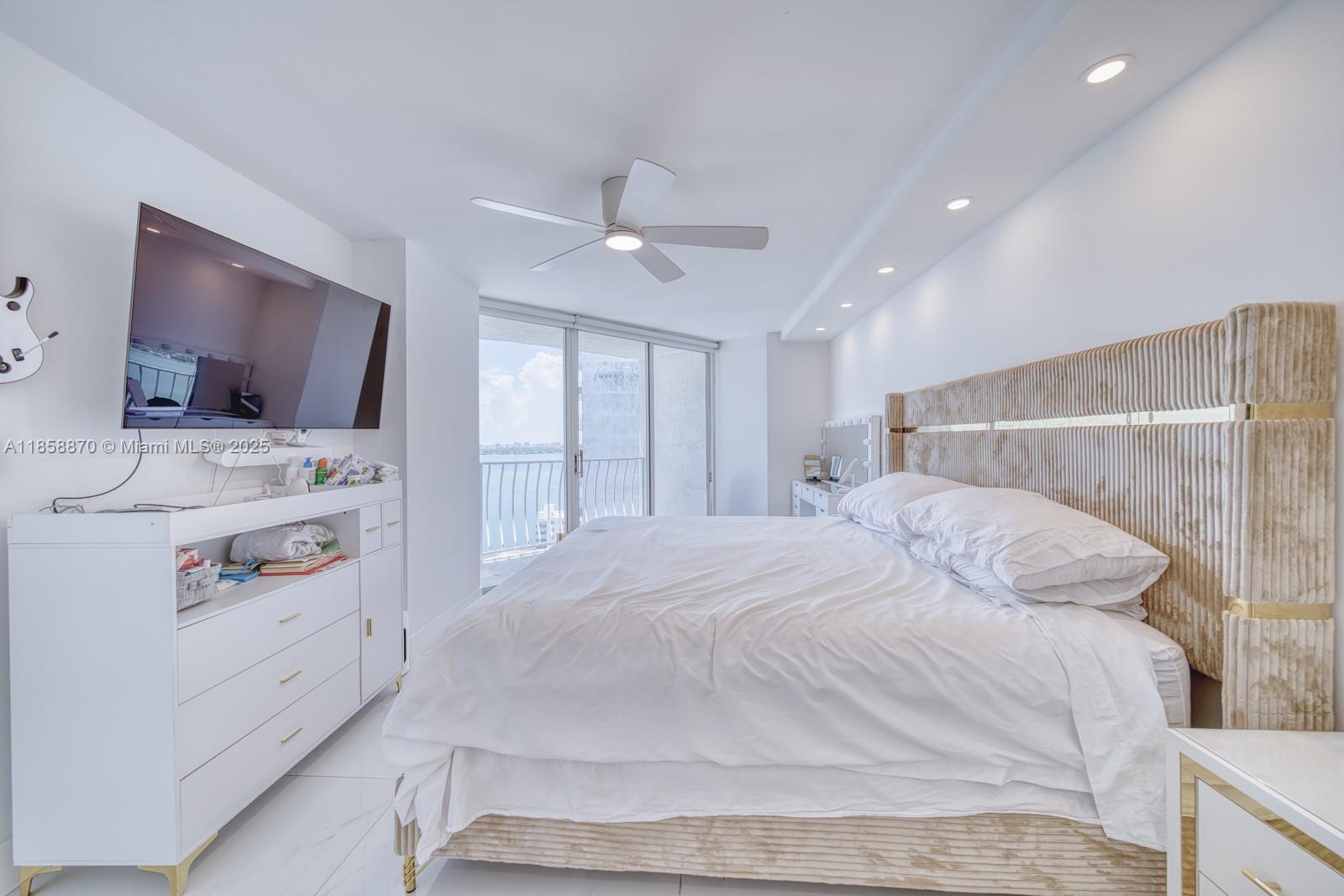 7601 East Treasure Drive, Unit 2424 North Bay Village, FL 33141 - Photo 15 of 25 a bedroom with a bed and a flat screen tv