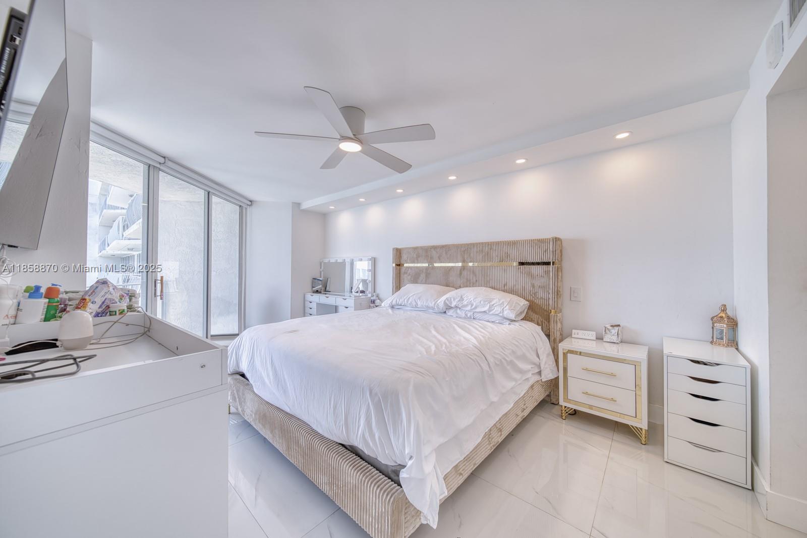 7601 East Treasure Drive, Unit 2424 North Bay Village, FL 33141 - Photo 16 of 25 a bedroom with a large bed and a chandelier