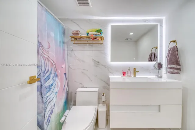 a bathroom with a sink a toilet and a shower curtain