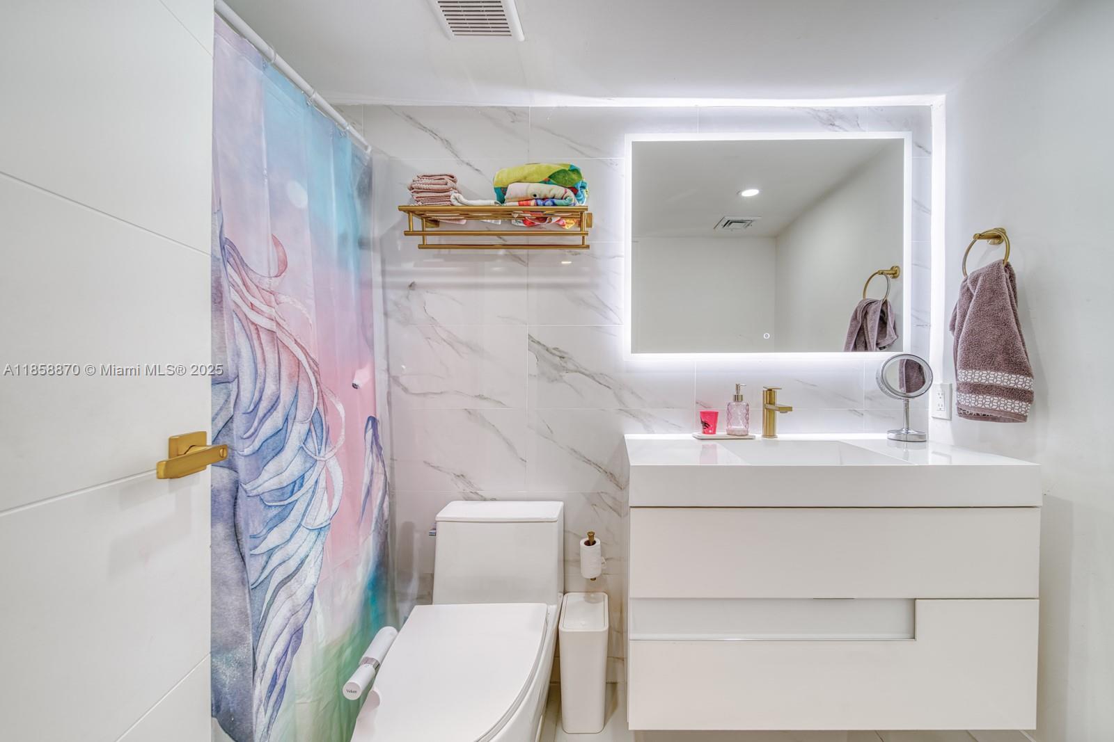 7601 East Treasure Drive, Unit 2424 North Bay Village, FL 33141 - Photo 19 of 25 a bathroom with a sink a toilet and a shower curtain