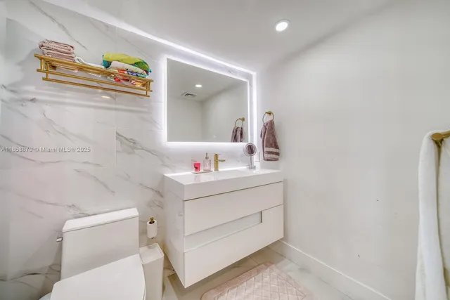 a bathroom with a sink mirror vanity and toilet