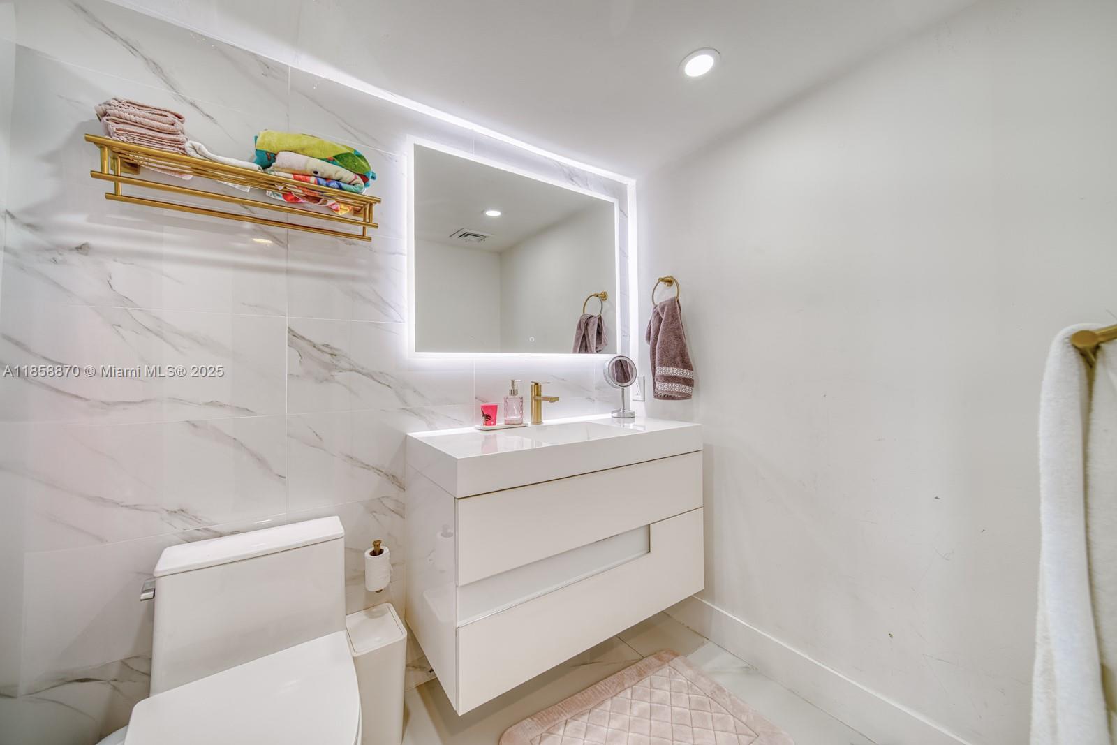 7601 East Treasure Drive, Unit 2424 North Bay Village, FL 33141 - Photo 20 of 25 a bathroom with a sink mirror vanity and toilet
