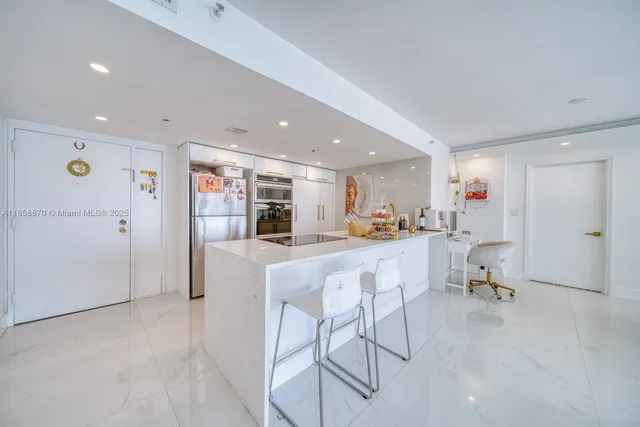 a living room with furniture and a dining table with kitchen view