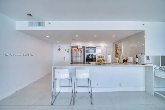 a kitchen with a sink counter and chairs